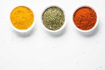 Set of three bowls with spices on white