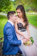 Bride and groom on bench in garden