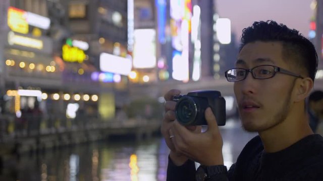 International tourist taking photos of the neon lights in Japan2