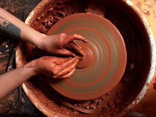 production process of pottery. Forming the clay cover of the kettle on the potter's wheel.