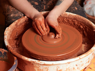 production process of pottery. Forming the clay cover of the kettle on the potter's wheel.