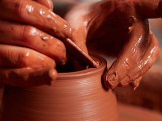 production process of pottery. Forming a clay teapot on a potter's wheel.