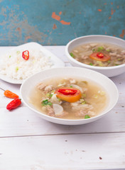 Soto or coto or indonesian beef soup served with white rice, tomato, soy, and green onion