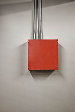 A red metal power junction box in a computer server farm.