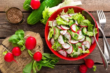 Zelfklevend Fotobehang Gerechten Vegetarische groentesalade van radijs, komkommer, slasalade en lijnzaad. Gezond veganistisch eten. Bovenaanzicht