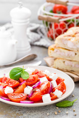 Tomato salad with fresh red onion and feta cheese. Healthy eating