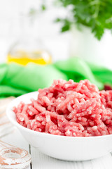 Forcemeat. Raw ground pork meat in bowl on white kitchen table. Fresh minced meat