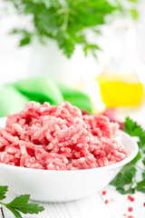 Forcemeat. Raw ground pork meat in bowl on white kitchen table. Fresh minced meat