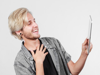 Trendy young man using tablet computer