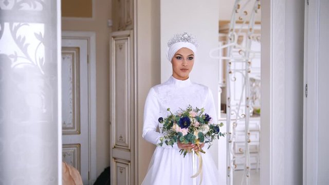 Beautiful muslim bride in wedding dress with bridal headdress in studio