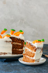 Carrot cake with cream cheese frosting decorated with carrot marmalade serving on a plate on a blue stone background. - 198029653
