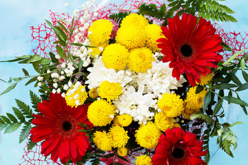 A wedding story or background Mother's Day. Basket bouquet of gerbera and chrysanthemums on a stone background or slate.