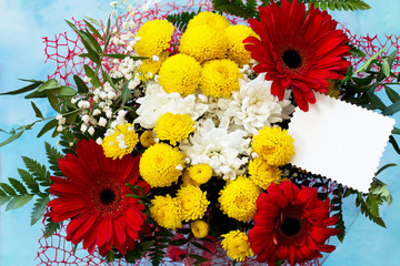 Mother's Day background or greeting card. Congratulatory sheet of paper withbouquet of gerbera and chrysanthemums on a stone background or slate with copy space.