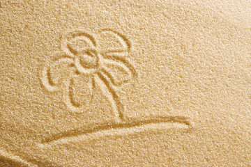 The flower is painted in the sand. Beach background. Top view. The concept of summer, summer kanikkuly, vacation, holydays.