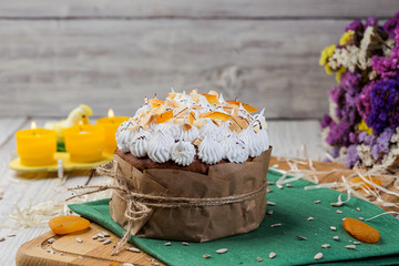Easter cake (bread) decorated with candies, dried apricots and sunflower seeds on wooden background. Holidays concept
