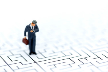 Miniature people :  businessman standing on  maze,Concepts of finding a solution, problem solving and challenge.