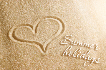 The heart is painted in the sand. Beach background. Top view. The concept of summer, summer kanikkuly, vacation, holydays.