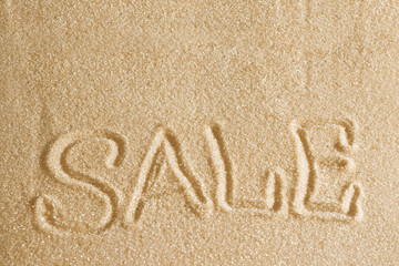 The word sale is painted in the sand. Beach background. Top view. The concept of summer, summer kanikkuly, vacation, holydays.