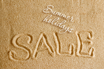 The word sale is painted on the sand and the inscription is a summer holiday. Beach background. View from above. The concept of summer, summer kanikkuly, vacation, holydays.
