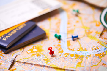pins marking travel itinerary points on map and passport