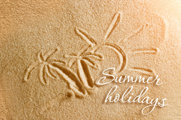 Palm trees are painted in the sand and the inscription is summer holidays. Beach background. View from above. The concept of summer, summer kanikkuly, vacation, holydays.