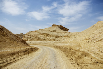 Fototapeta na wymiar A country road between the old white mountains of the Arava desert