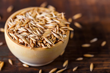 Close up oat grains in wooden bowl