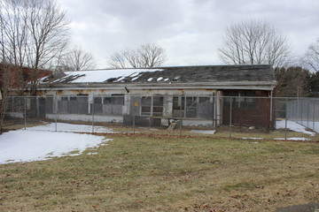 Obraz premium Old abandoned and boarded up brick asylum hospital building