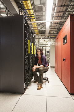 Caucasian woman technician in a large computer server farm.