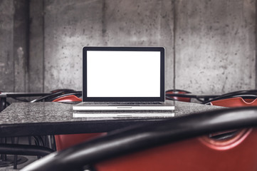 Laptop screen in styled place with cement walls. Mock up.