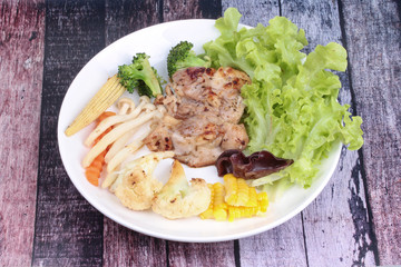 Chicken steak and grilled mixed vegetables .