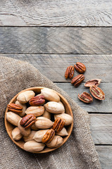 Pecan nuts on wooden table. Vertical food photo.