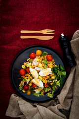 Salad of pasta, egg, smoked salmon tartare, salad and tomato, with a citrus vinaigrette sauce.