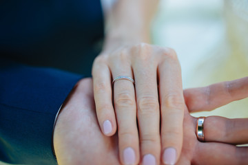 Lovers holding hands with gold wedding rings