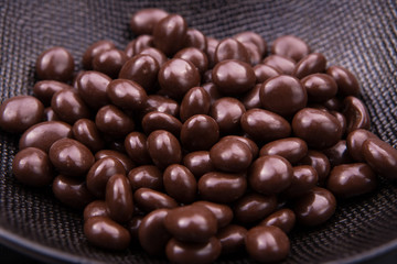 Chocolate ball candy smarties on black background with nuts inside - 198034299