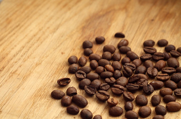 Coffee beans on wooden board with blur effect.