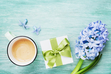 Mothers Day spring greeting background with flowers, gift or present box and cup of coffee top view. Morning breakfast for holiday.