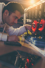 Programmer adjusting cryptocurrency mining rig