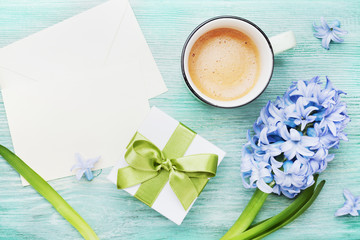 Mothers Day greeting background with holiday postcard, flowers, gift or present box and cup of coffee on table top view.