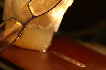 Cold beverage plastic cup and eye glasses put on notebook scene.