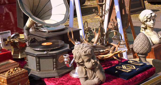 Stand auf einem Flohmarkt mit altem Grammophon samt Schallplatte und B&uuml;ste einers Knaben im Vordergrund