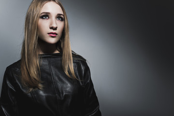 Young female model in black dress on the contrast black and white background