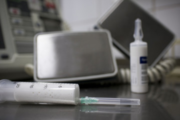 cardiac defibrillator and the syringe of propofol on the medical table