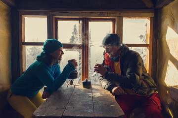 Happy couple of travelers is drinking coffee