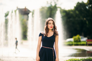 Obraz premium A girl is walking around the city, near a large fountain.