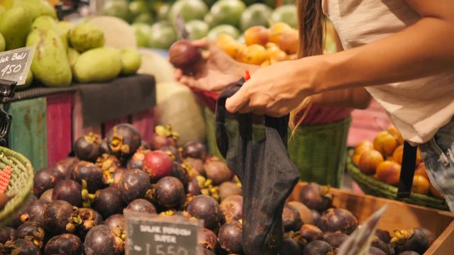 Young Mixed Race Woman Shopping without Plastic Bags in Grocery Store. Vegan Zero Waste Girl Choosing Fresh Exotic Fruits in Supermarket. 4K.
