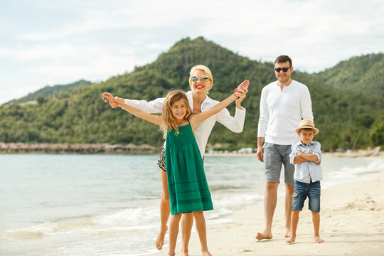 beautiful happy family posing on beach of tropical island