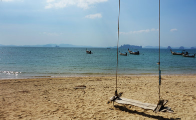 Summer, Travel, Vacation and Holiday concept - Swing hang from tree over beach sea in Khlong Muang Beach, Krabi,,Thailand.