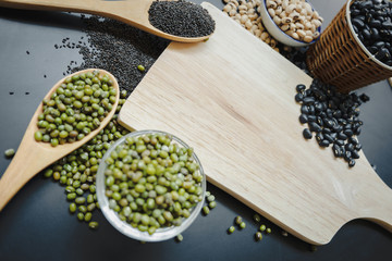 chopping board with whole grains on the black table and  copy space.
