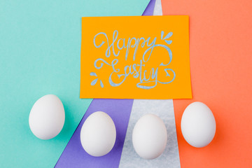 Happy Easter background with eggs. Yellow Easter greeting card and row of white eggs on colorful background. Wishing for happy Easter.